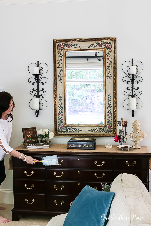 lady dusting a dresser