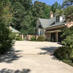 concrete driveway with brick house