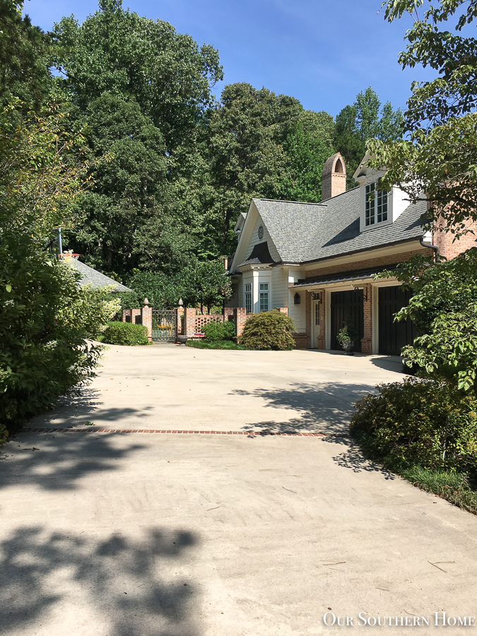 concrete driveway with brick house