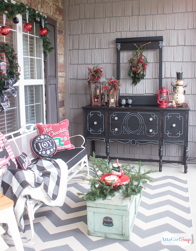 It all started with some gorgeous, wide chalkboard ribbon. Throw in a some vintage Christmas decorations, greenery and ample pops of red, and the result is a gorgeous front porch decorated for Christmas. Who wouldn't want to spend time relaxing in this beautiful space? It's so welcoming and festive!