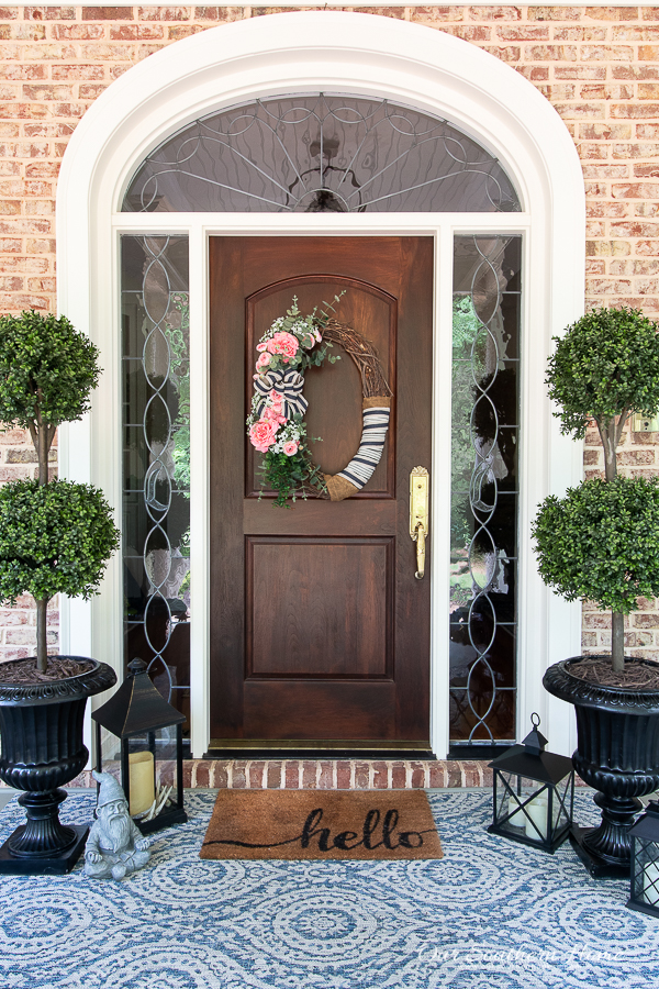 front door with topiaries and rug
