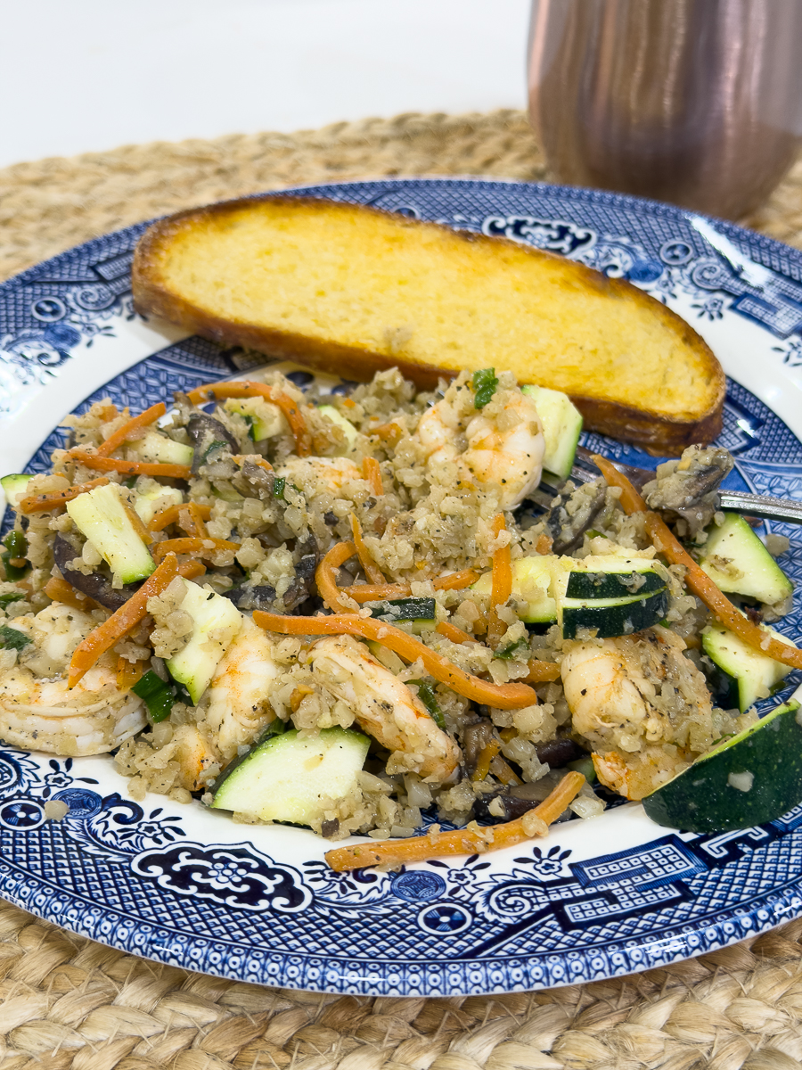 Plate of shrimp cauliflower fried rice with vegetables and toasted bread