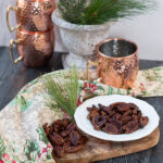 pecans on a dish with copper mugs