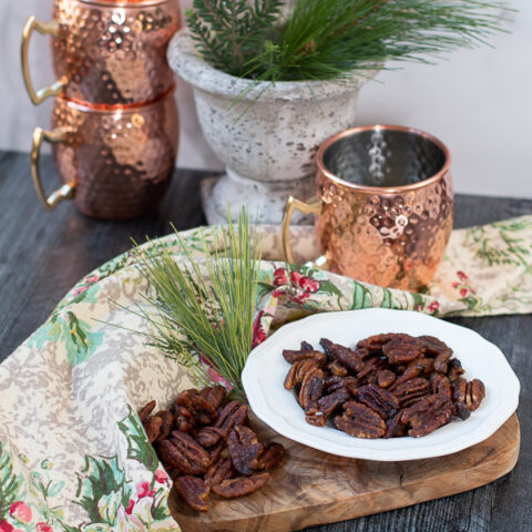 pecans on a dish with copper mugs