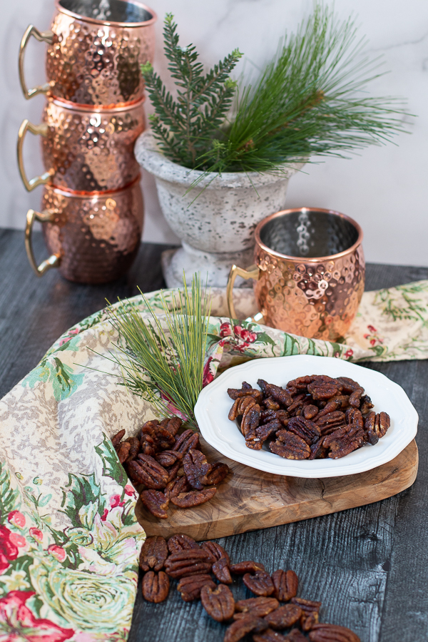 pecans on a dish with copper mugs