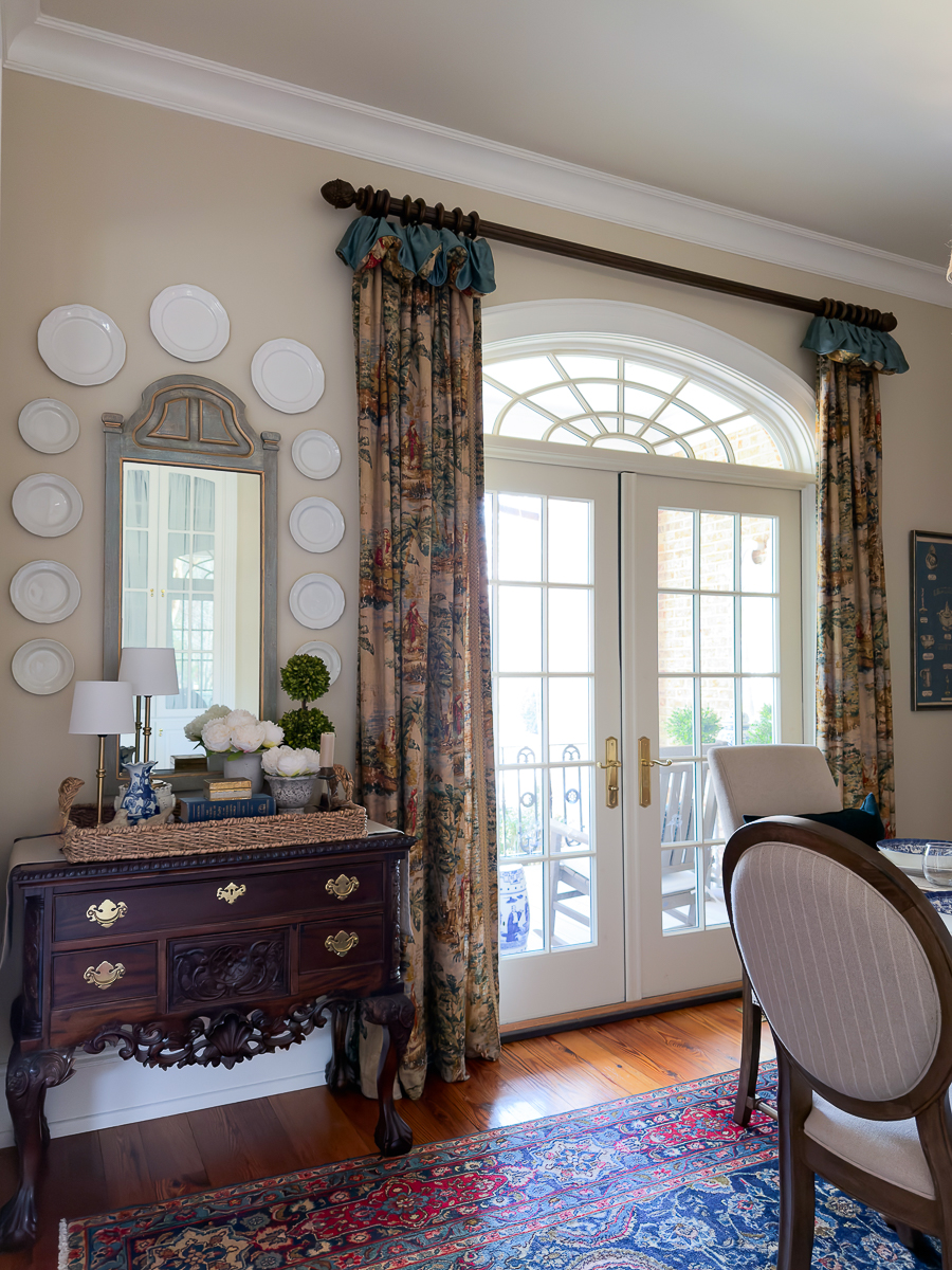 Traditional spring entryway with vintage chest, woven tray, peonies, and boxwood topiary.