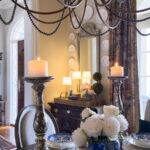 Spring vignette styled on antique chest with woven tray, peonies, and vintage decor.
