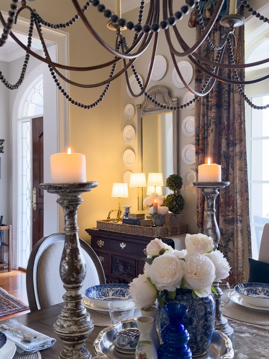 Spring vignette styled on antique chest with woven tray, peonies, and vintage decor.