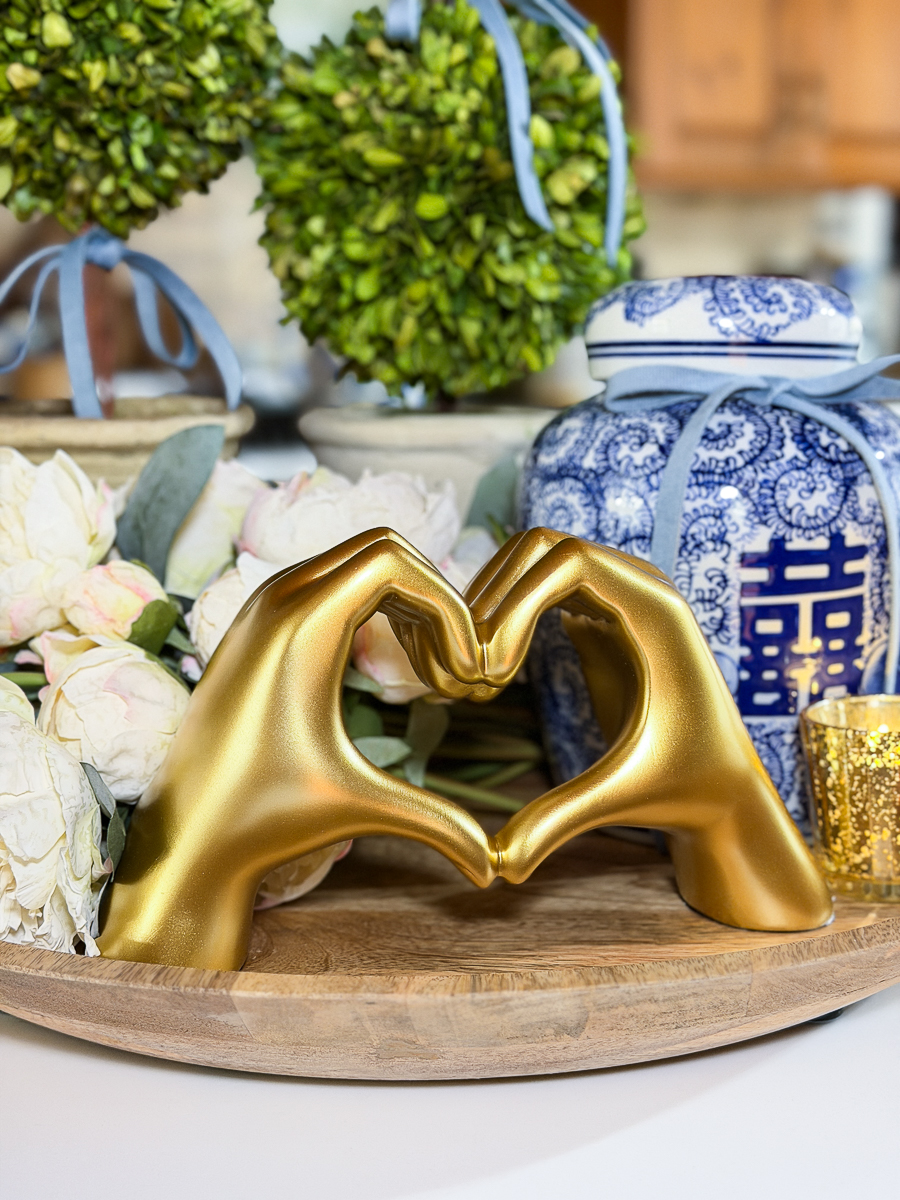 Elegant Valentine’s kitchen decor with gold heart sculpture and candle.