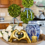 Classic Valentine’s kitchen island decor with gold heart hands sculpture.