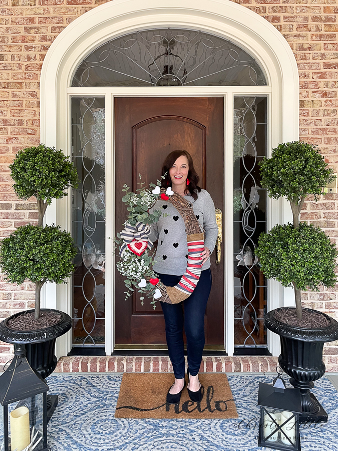 woman on front porch holding wreath