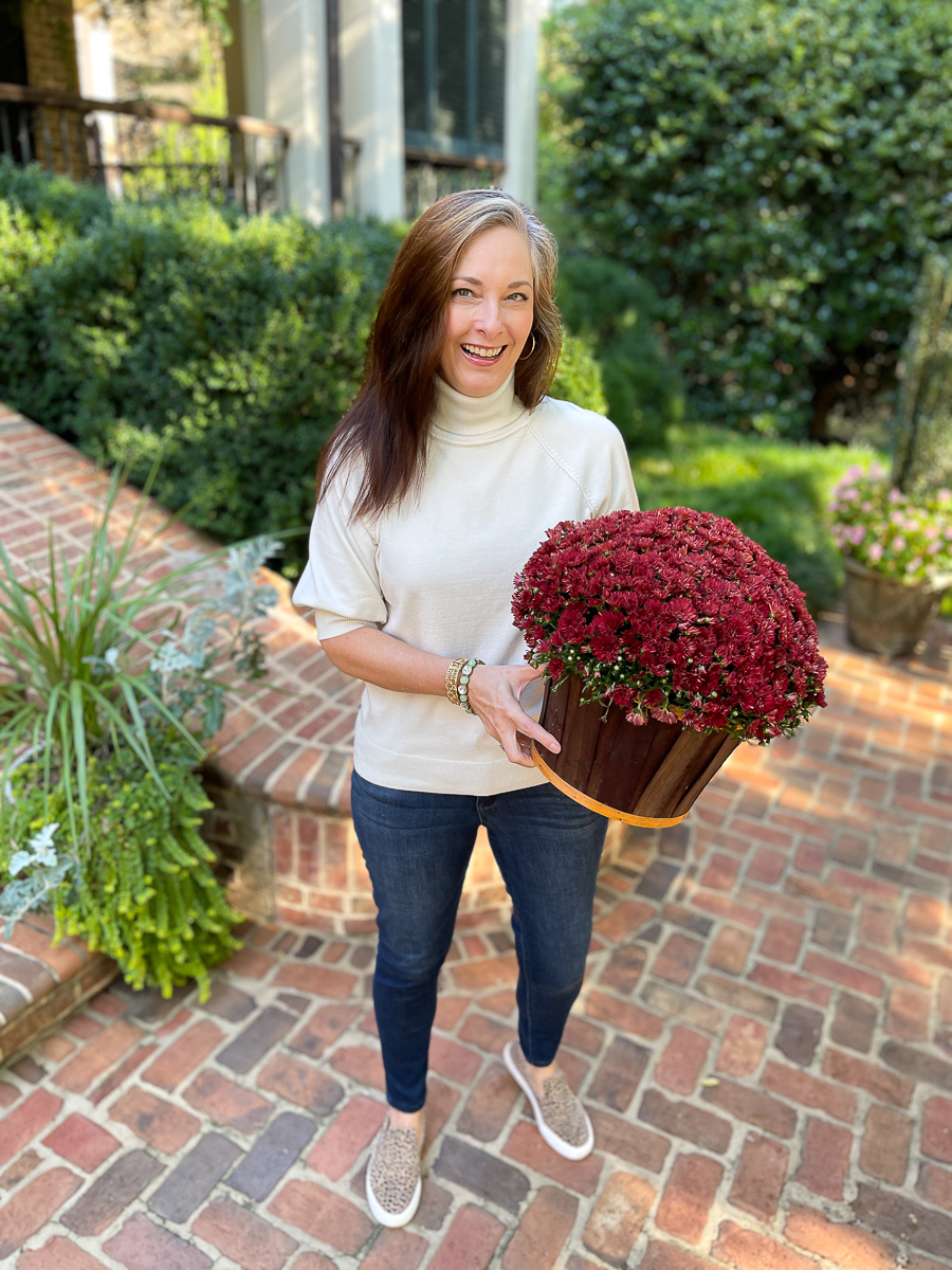 woman holding a mum on a patio