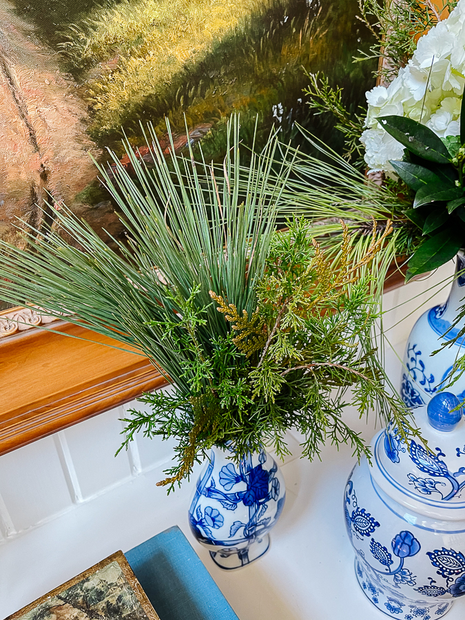 winter floral arrangement with blue and white porcelain in front of oil painting